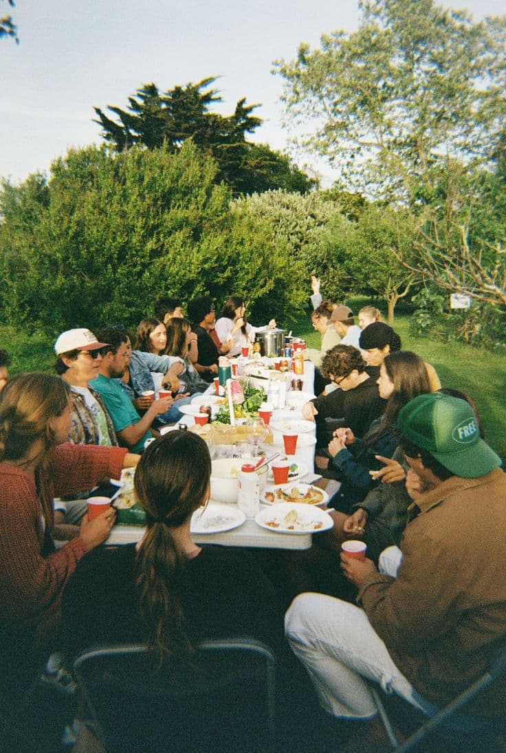 Amigos compartiendo una mesa larga al aire libre