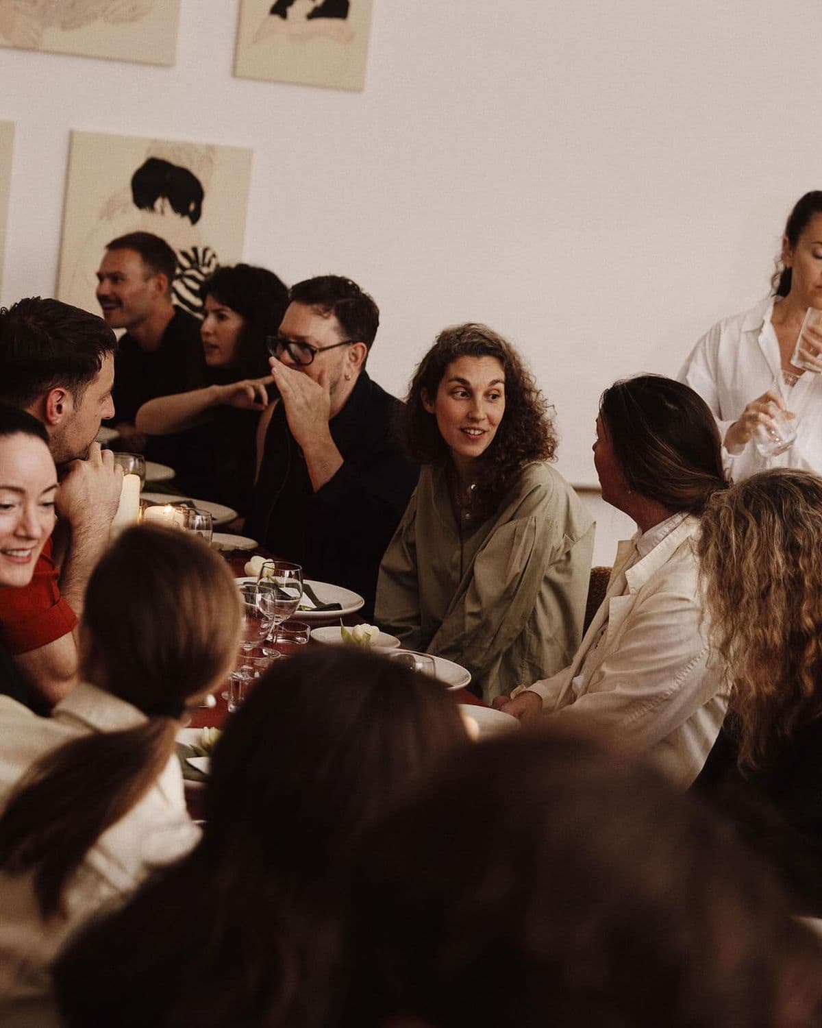 Invitados conversando alrededor de una mesa en una cena privada